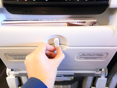 A commercial airplane folding seatback tray