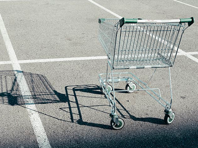 A lone chopping cart in an empty parking lot